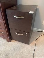 Front view of two-drawer cabinet showing silver handles and lock