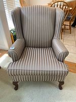 Front view of striped wingback chair showing overall design and upholstery pattern