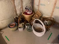 Group shot showing all wicker baskets, ceramic planters, plaque and glass vase arranged on floor