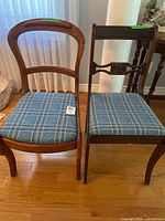 Both wood chairs side by side showing design differences and plaid cushions