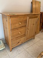 Front view showing 3 drawers, paneled door, knobs, flat top