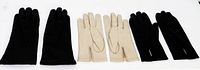 Three pairs of small ladies gloves laid flat: black pair, beige pair, black pair