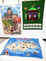 Three tea towels displayed; Quebec, Scandinavia calendar, Nassau Bahamas