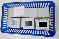 Basket containing numerous cardboard-mounted slides, handwritten labels visible