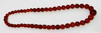 Entire necklace laid flat showing graduated amber beads