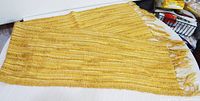 Full view of yellow mohair scarf laid flat showing overall size and fringe