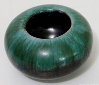 Top and side view of round green drip glaze vase