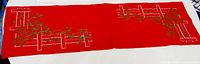 Full view of red embroidered table runner laid flat
