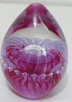 Overall view of egg-shaped glass paperweight showing internal floral design
