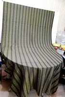 Full view of tablecloth draped over round table showing size and overall stripe pattern