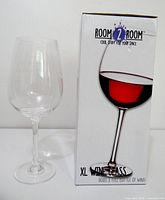 Wine glass beside original box, showing branding and product