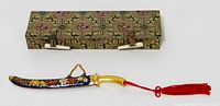 Letter opener sheathed in cloisonné scabbard beside patterned presentation box