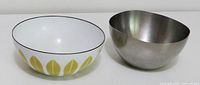 Enamel bowl and brushed metal bowl side by side, interior view