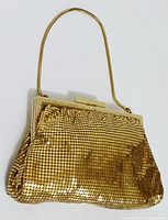 Front view of gold metal mesh evening handbag with chain handle and clasp