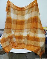 Full view of mohair blanket draped to show size and plaid pattern