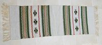 Full length view of woven wool table runner with fringe