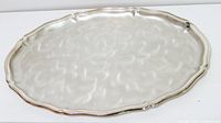 Top view of oval silver-plated tray showing scalloped rim and brush swirl finish
