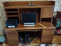 Front view of desk with HP monitor, Samsung printer on surface, desktop tower and cables below