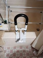 Clamp-on bathtub grab handle attached to tub