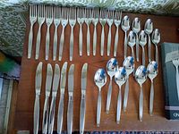 Flatware laid out showing forks, knives, spoons