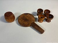 Cheese board, condiment jar, spreader, four egg cups grouped