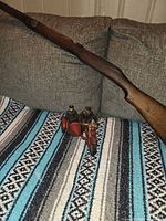 Overall view of rifle stock, motorcycle toy and rider figures