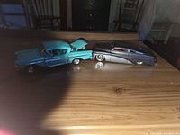 Both diecast cars side by side showing scale and colour