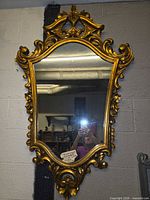Full view of gilded Baroque mirror hanging on wall