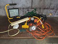 Group view of cords, work light, drop light, power strips and adapters