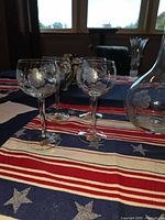 Three etched crystal wine glasses and partial view of decanter