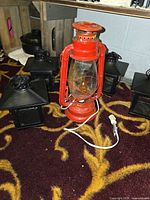 Group view showing red electric railroad lantern and four black mini lanterns