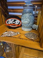 Full lot showing Avon fish stein, Harley-Davidson jewelry holder, two metal belt buckles