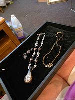 Two necklaces and earrings displayed in tray