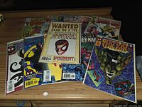 Group shot of all eleven bagged Spider-Man comics spread on a wooden surface