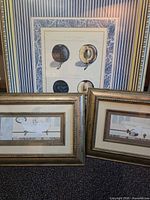 All three framed prints standing together showing relative sizes and designs
