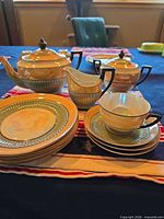 Full set view: teapot, creamer, sugar, stacked plates, cup on saucer.