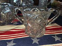 two-handled candy dish showing starburst sides and sawtooth rim