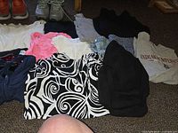 Assorted clothing pieces and both pairs of boots laid out