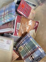 Assorted sealed pillowcase and protector packages in bin
