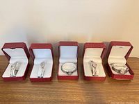 Five silver-tone fashion wristwatches in boxes
