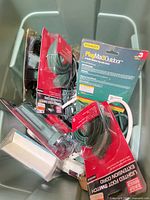 Overview of bin containing packaged stakes, taps, cords and loose items