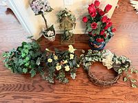 All six artificial floral décor items arranged on hardwood floor