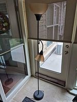 Full view of black metal torchiere floor lamp with side reading light