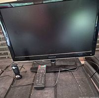 Front view of Proscan TV with remote and ClearTV dongle