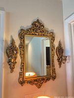 Mirror and both sconces mounted on wall to show design and scale