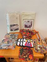Group shot of all tablecloths, placemats, oven mitts, pot holders on table