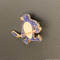 Front view of enamel skating penguin logo pin