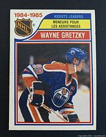 Front of O-Pee-Chee Wayne Gretzky assists leaders card showing year header, NHL logo, player image
