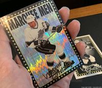 Front of holographic Bower Boosters parallel card held in hand