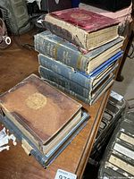 Stack of eight worn Boer War books showing mixed bindings and sizes